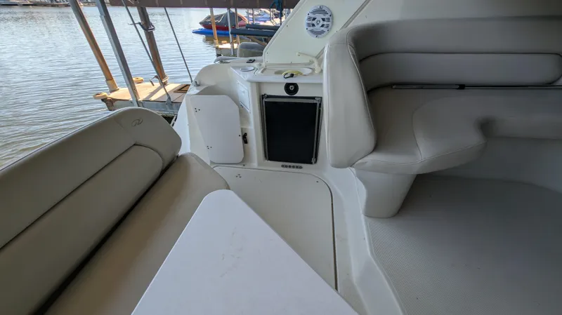 Slide: The Image of 2000 Regal 2860 Commodore boat interior with white seating and water view. - 16