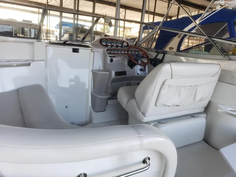 Slide: The Image of Interior of a 2000 Regal 2860 Commodore boat with white seating and control panel. - 17