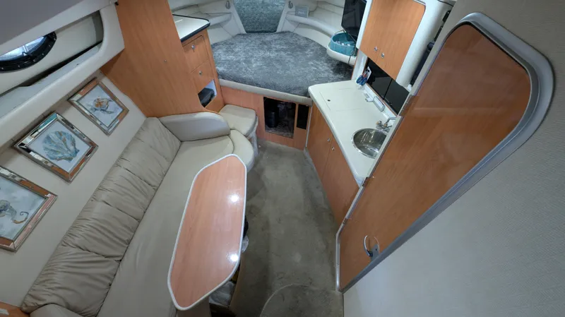 Slide: The Image of Interior of 2000 Regal 2860 Commodore boat with cozy seating and compact kitchenette. - 18