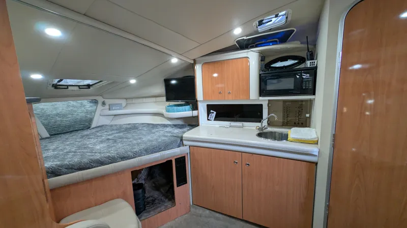Slide: The Image of Interior of 2000 Regal 2860 Commodore boat with bed, kitchenette, and storage. - 19