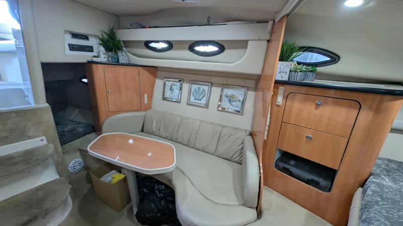 Slide: The Image of Interior of 2000 Regal 2860 Commodore boat with seating, table, and storage cabinets. - 21