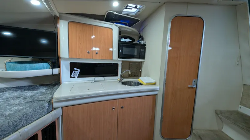Slide: The Image of Interior of a 2000 Regal 2860 Commodore boat with kitchenette and wooden cabinetry. - 22