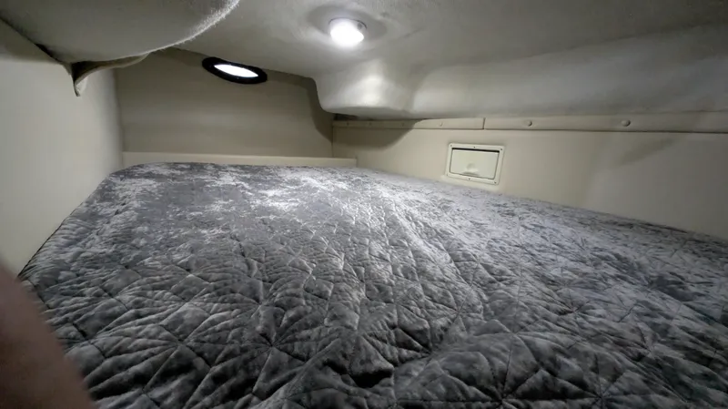 Slide: The Image of Cozy cabin interior of 2000 Regal 2860 Commodore with quilted bedding and soft lighting. - 26