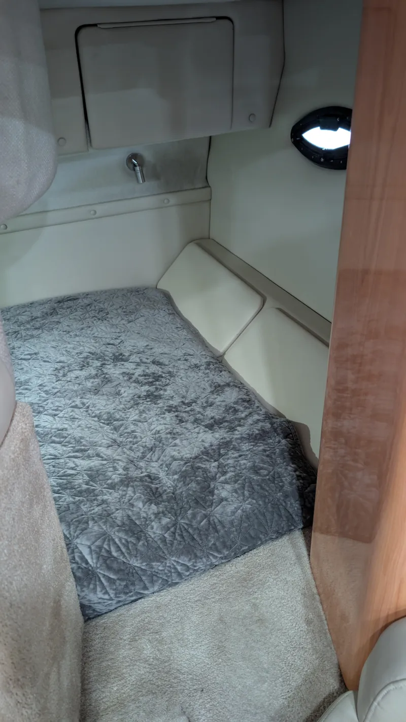 Slide: The Image of 2000 Regal 2860 Commodore cabin interior with plush gray carpeting and compact design. - 27
