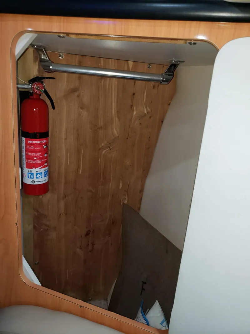 Slide: The Image of Fire extinguisher in 2000 Regal 2860 Commodore boat interior with wooden paneling. - 43