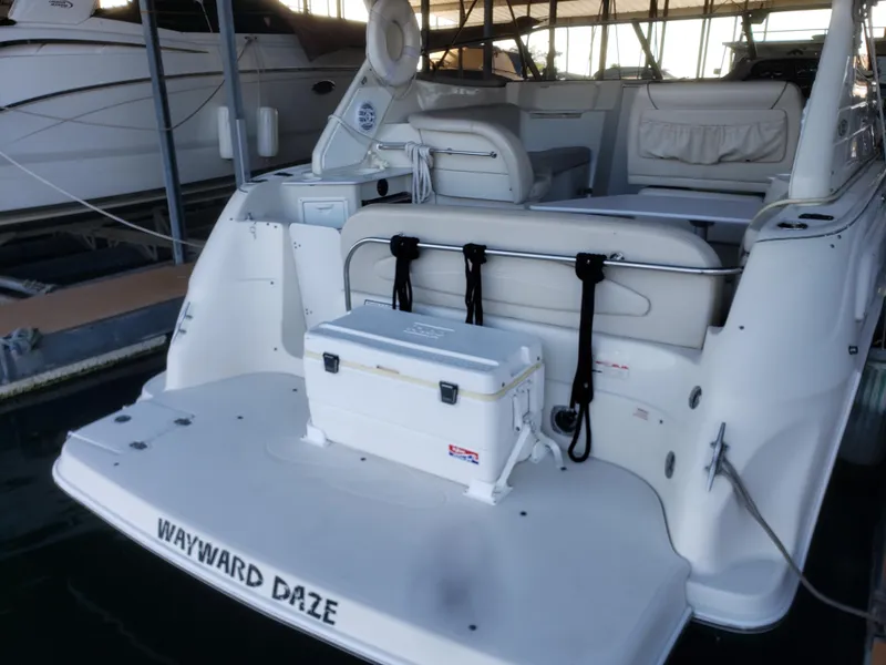 Slide: The Image of 2000 Regal 2860 Commodore boat docked, featuring spacious deck and seating area. - 6