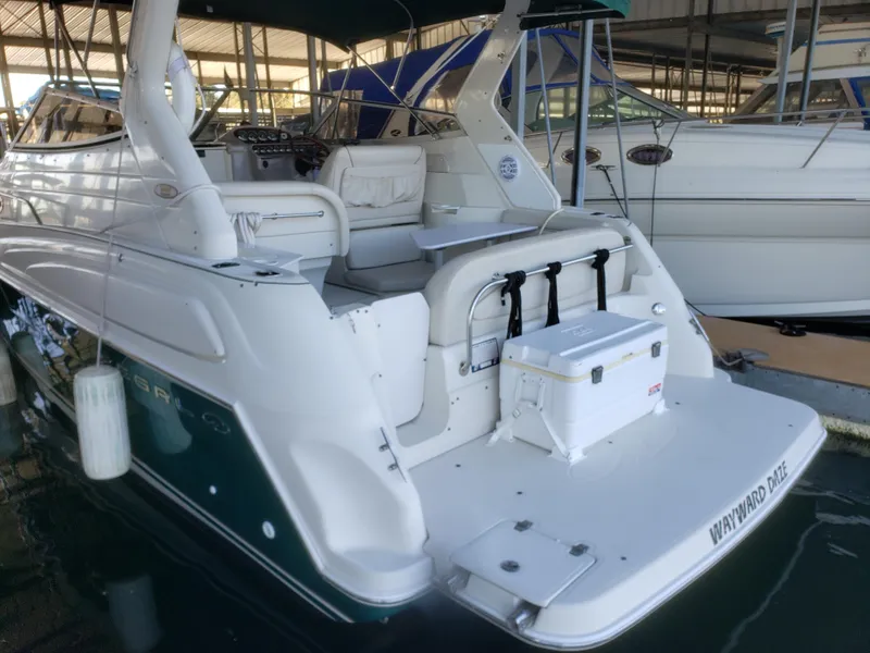 Slide: The Image of 2000 Regal 2860 Commodore boat docked, featuring spacious deck and seating area. - 7