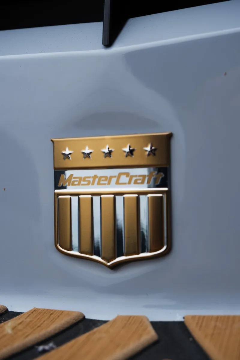 Slide: The Image of 2025 MasterCraft XStar 23 emblem with gold stars and stripes on a sleek surface. - 10