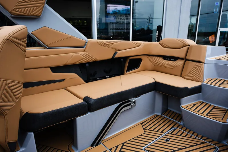 Slide: The Image of 2025 MasterCraft XStar 23 interior with tan and black seating, showcasing modern design and comfort. - 13