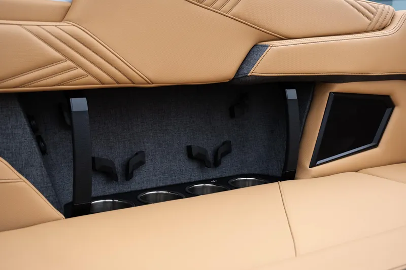 Slide: The Image of 2025 MasterCraft XStar 23 interior with tan upholstery and integrated cup holders. - 14