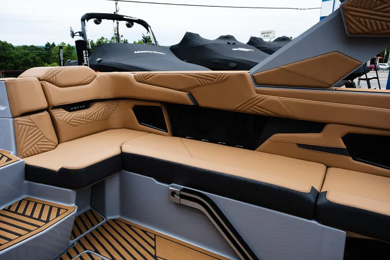 Slide: The Image of 2025 MasterCraft XStar 23 interior with luxurious tan and black seating, showcasing modern design. - 16