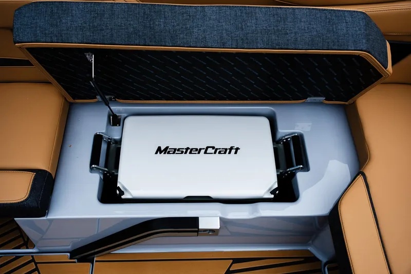 Slide: The Image of 2025 MasterCraft XStar 23 boat storage compartment with branded cooler. - 17