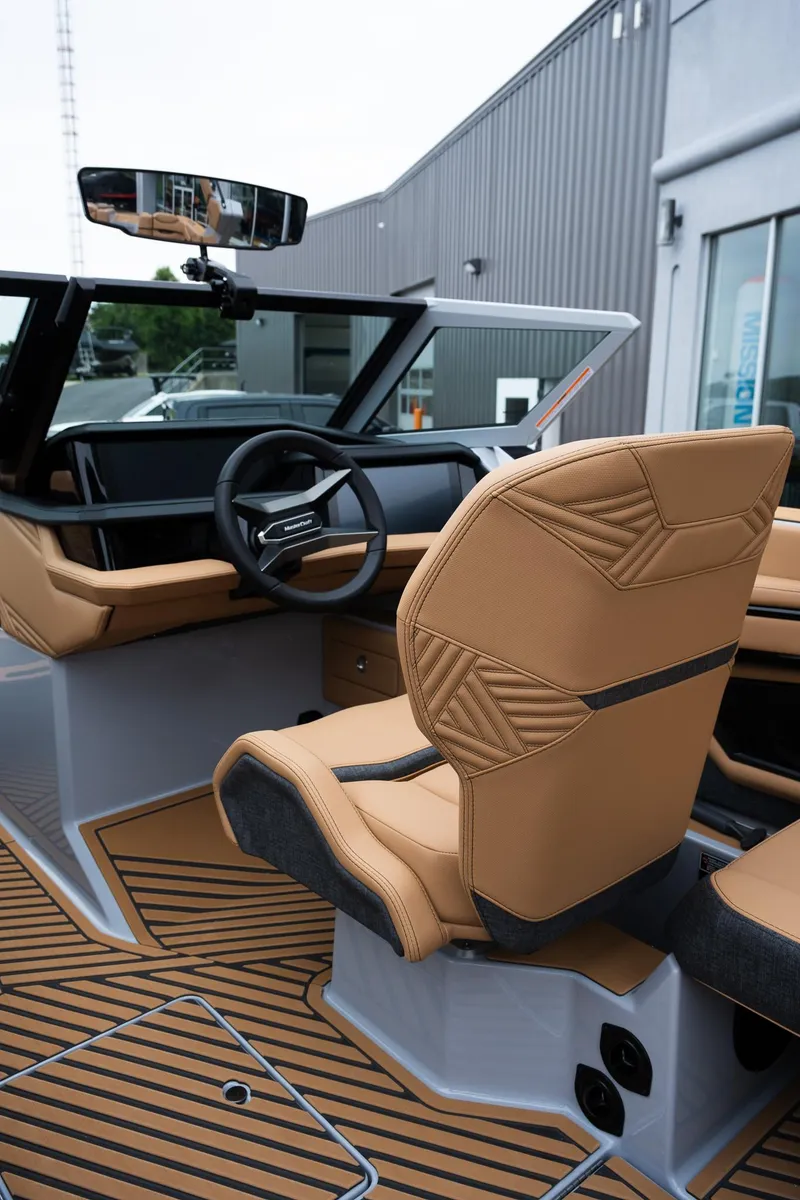 Slide: The Image of 2025 MasterCraft XStar 23 boat interior with tan seats and modern dashboard design. - 23