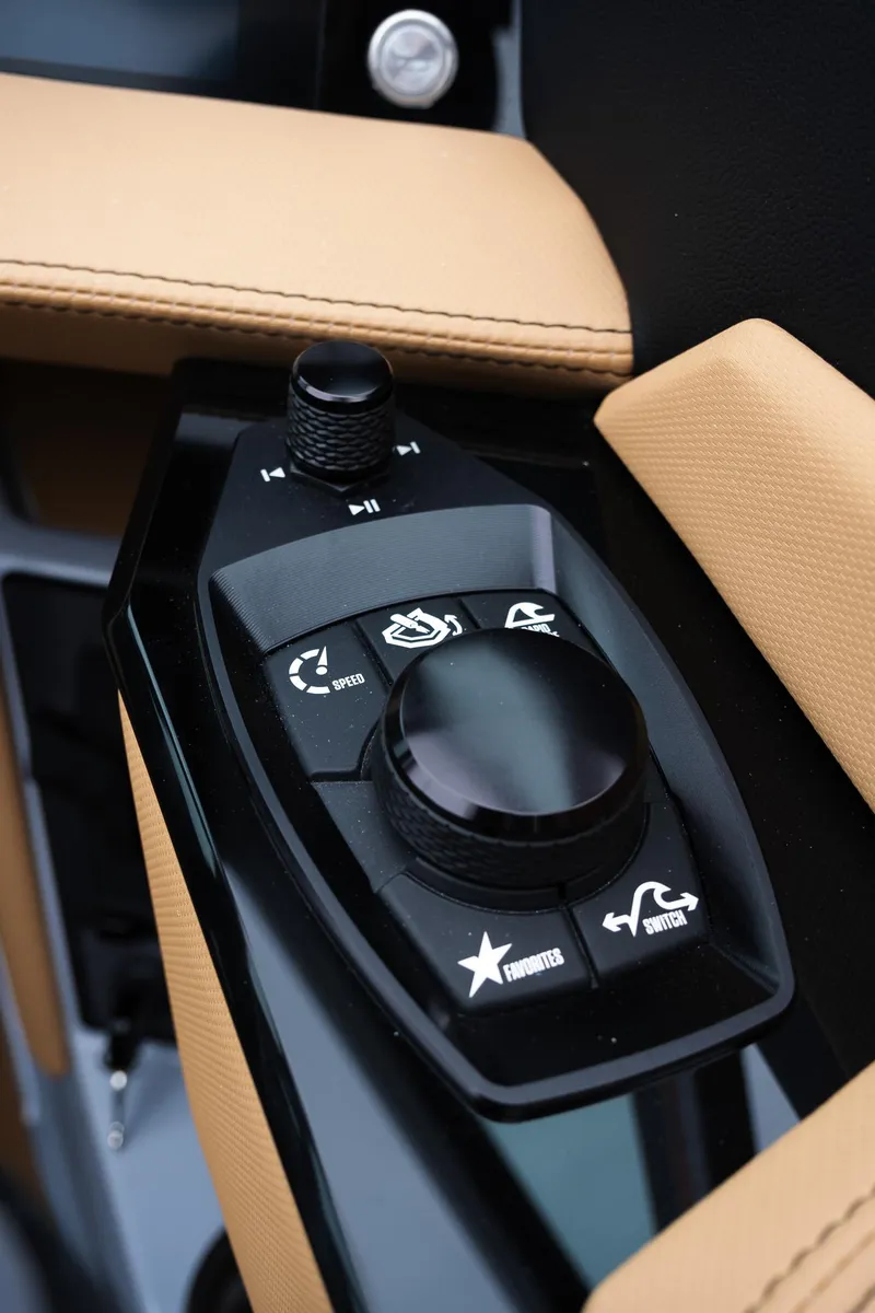 Slide: The Image of 2025 MasterCraft XStar 23 control panel with beige upholstery and black buttons. - 24