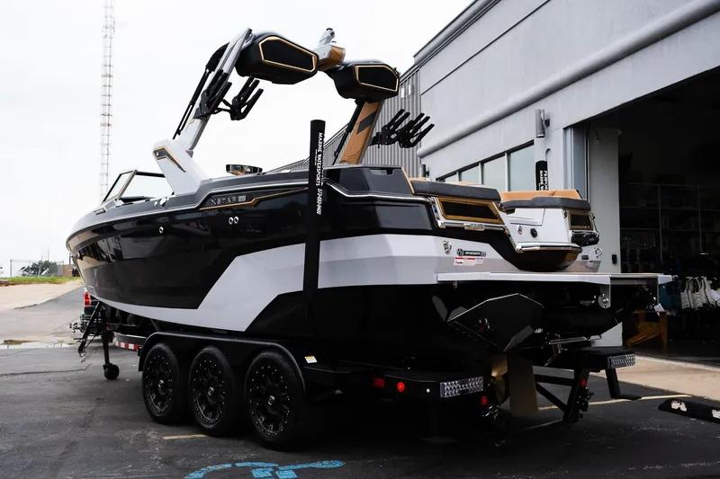 Slide: The Image of 2025 MasterCraft XStar 23 boat on a trailer, parked outside a building. - 5