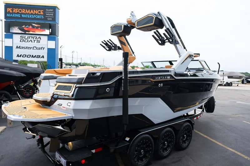 Slide: The Image of 2025 MasterCraft XStar 23 boat on trailer at dealership, showcasing sleek design and modern features. - 9