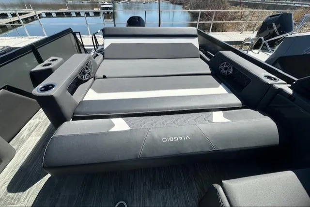 Slide: The Image of Luxurious 2025 Viaggio Diamante S boat seating with cup holders and speakers, docked by the water. - 42