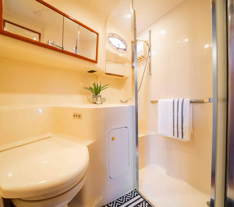Slide: The Image of Bathroom interior of a 1998 Sea Ray 400 Sedan Bridge yacht, featuring shower and toilet. - 14