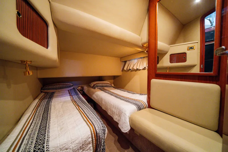 Slide: The Image of Interior of 1998 Sea Ray 400 Sedan Bridge with twin beds and wooden accents. - 16