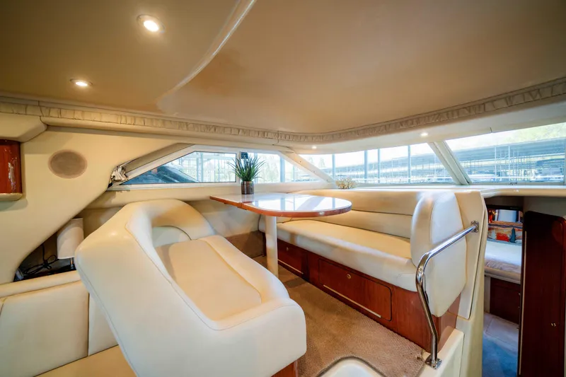 Slide: The Image of 1998 Sea Ray 400 Sedan Bridge interior with plush seating and dining area. - 19