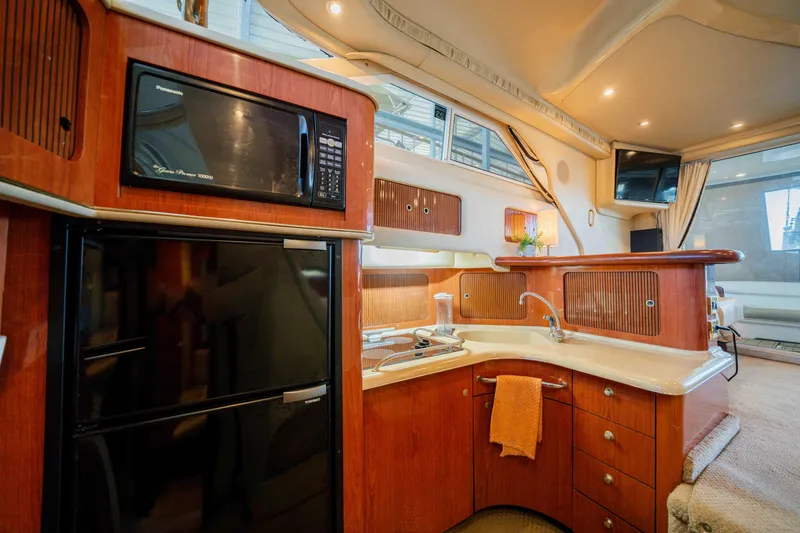 Slide: The Image of Luxurious interior of 1998 Sea Ray 400 Sedan Bridge yacht with modern kitchen amenities. - 22
