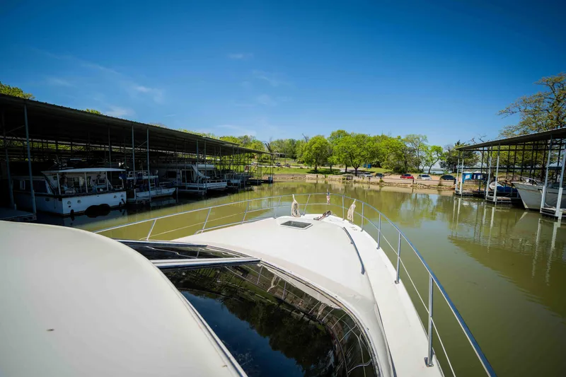 Slide: The Image of 1998 Sea Ray 400 Sedan Bridge docked in a marina under clear blue skies. - 26