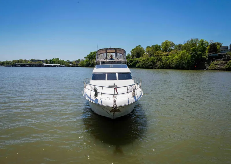 Slide: The Image of 1998 Sea Ray 400 Sedan Bridge yacht on a calm river under clear blue sky. - 3