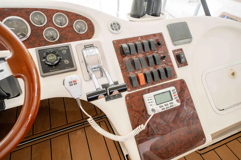 Slide: The Image of 1998 Sea Ray 400 Sedan Bridge helm with controls, gauges, and wood accents. - 35