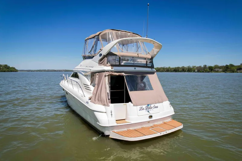 Slide: The Image of 1998 Sea Ray 400 Sedan Bridge yacht on calm water under clear blue sky. - 7