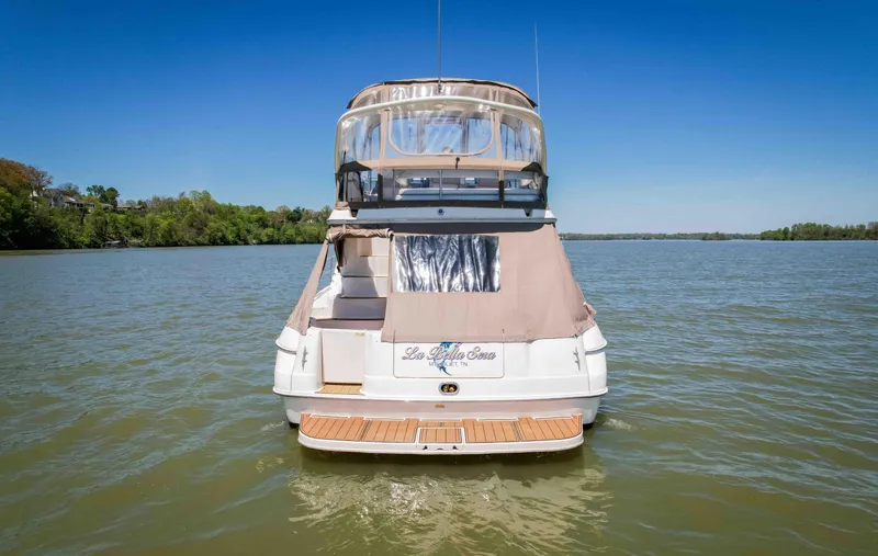 Slide: The Image of 1998 Sea Ray 400 Sedan Bridge yacht on calm water, rear view. - 8