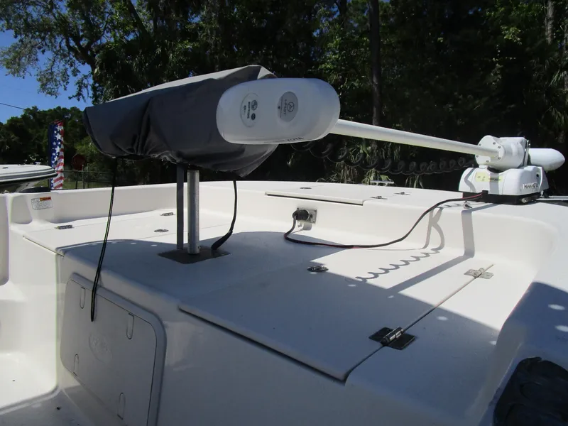 Slide: The Image of 2020 Carolina Skiff 19 LS boat deck with mounted trolling motor, surrounded by lush greenery. - 5