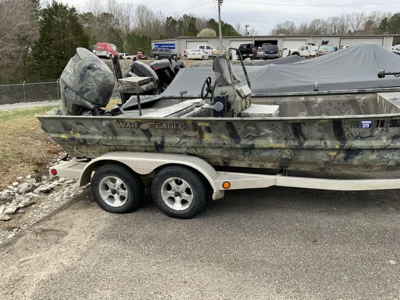 Slide: The Image of 2006 War Eagle 2072CC boat on trailer, camo design, parked outdoors. - 2