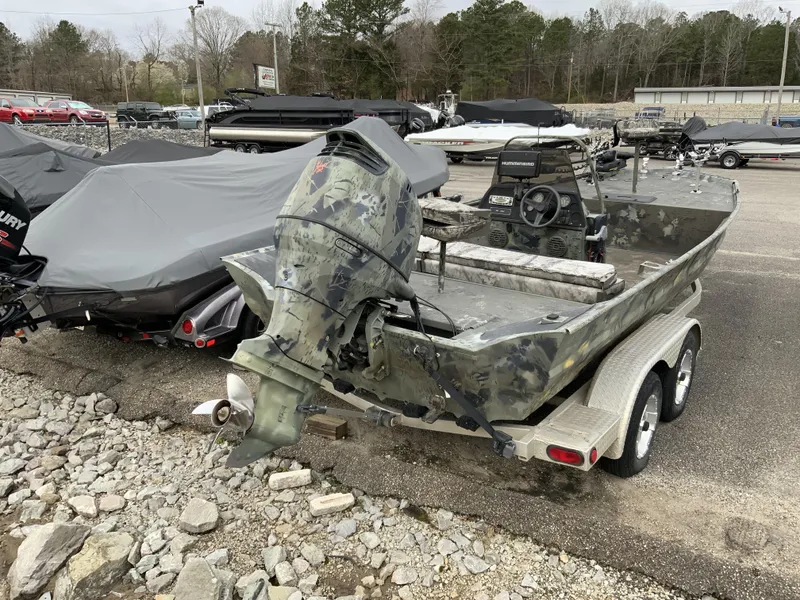 Slide: The Image of 2006 War Eagle 2072CC boat with camouflage design, parked on a trailer in a lot. - 4