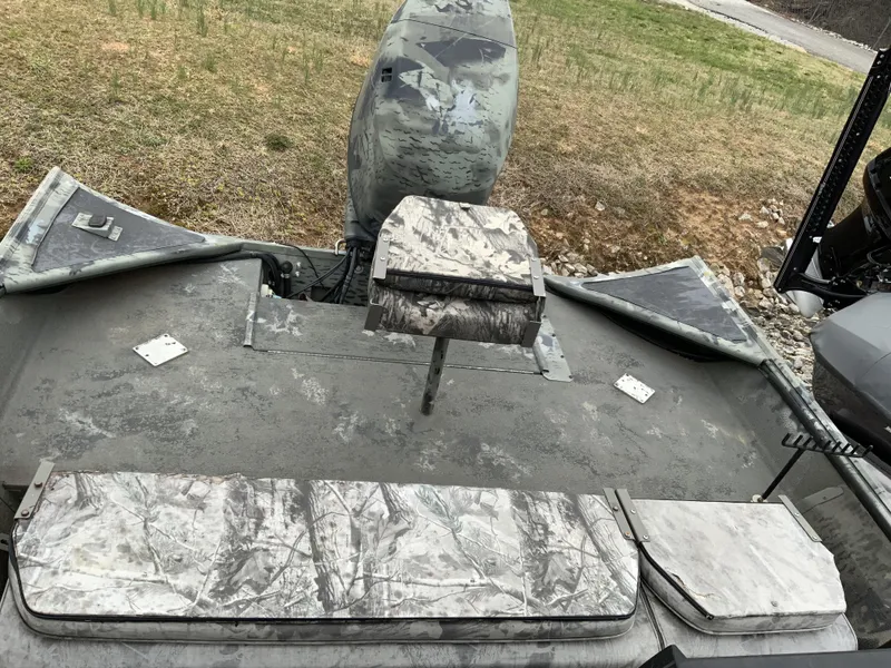 Slide: The Image of 2006 War Eagle 2072CC boat with camouflage seating and motor, parked on grassy terrain. - 9