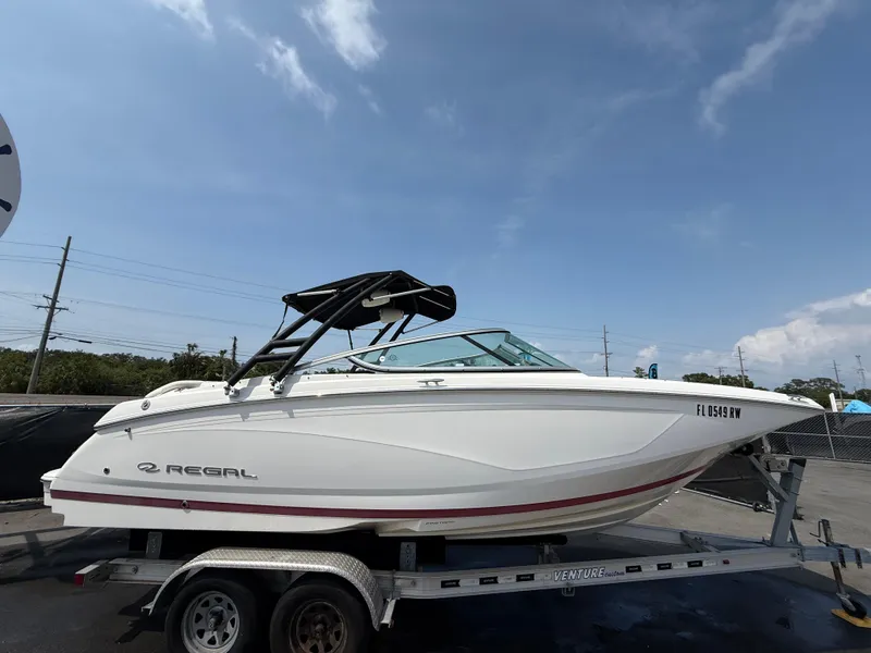 Slide: The Image of 2017 Regal 22 FasDeck boat on trailer under clear sky. - 2