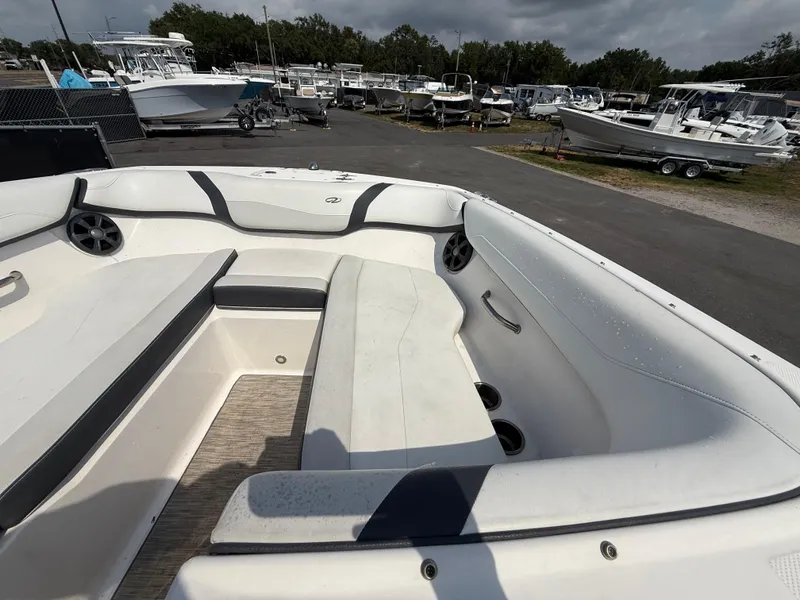 Slide: The Image of 2017 Regal 22 FasDeck boat interior with white seating and cup holders, parked in a marina. - 46