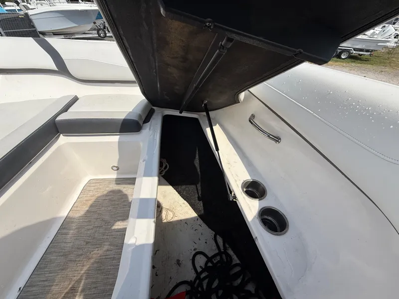Slide: The Image of 2017 Regal 22 FasDeck boat interior storage compartment with open hatch and cup holders. - 47