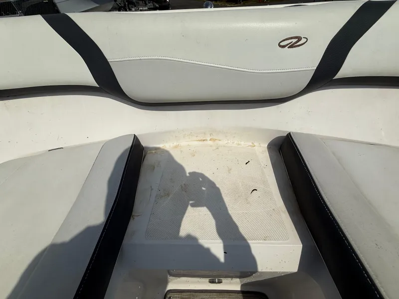 Slide: The Image of Interior seating of a 2017 Regal 22 FasDeck boat, featuring white and black upholstery. - 49