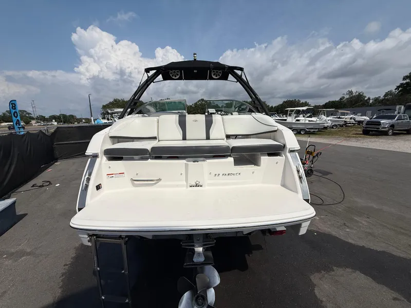 Slide: The Image of 2017 Regal 22 FasDeck boat, rear view, parked on pavement under a cloudy sky. - 8