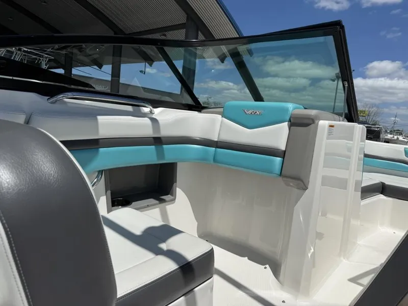 Slide: The Image of 2016 Chaparral VRX 203 boat interior with blue and white seating under a clear sky. - 4