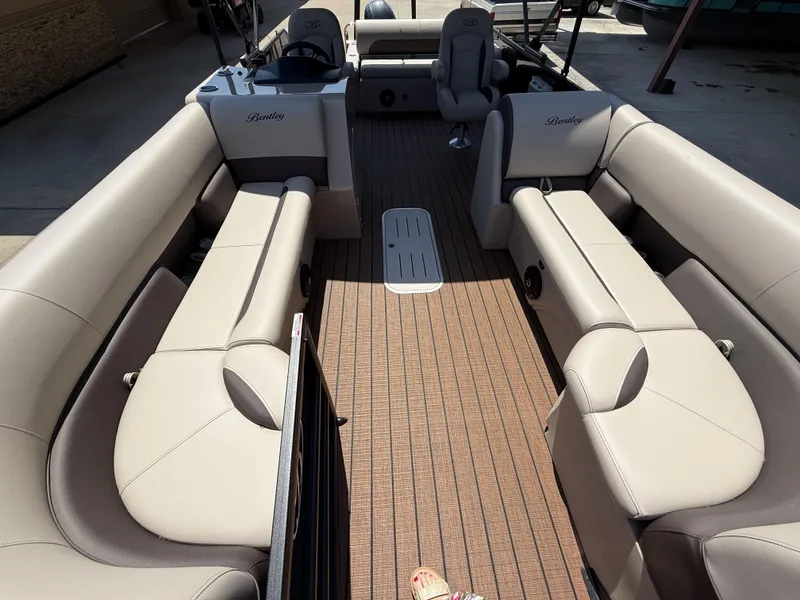 Slide: The Image of 2025 Bentley Pontoons Legacy 243 Swingback interior with beige seating and wood-style flooring. - 12