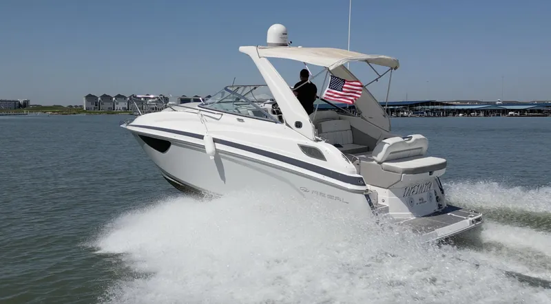 Slide: The Image of 2020 Regal 28 Express boat cruising on water with American flag. - 1