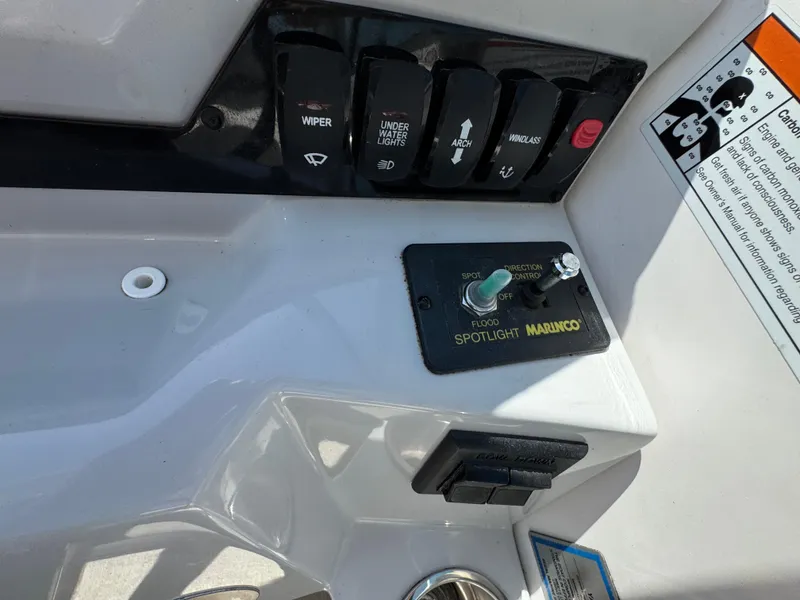 Slide: The Image of Control panel of a 2020 Regal 28 Express boat with switches and spotlight controls. - 12