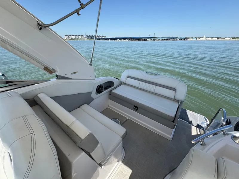Slide: The Image of 2020 Regal 28 Express boat interior with white seating, overlooking calm waters. - 19