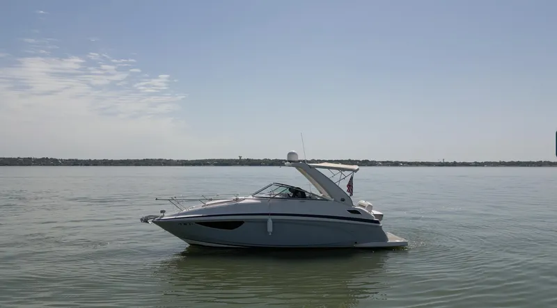 Slide: The Image of 2020 Regal 28 Express boat on calm water under clear sky. - 2