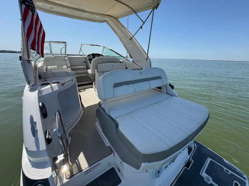 Slide: The Image of 2020 Regal 28 Express boat interior with seating, on calm water, under clear blue sky. - 24