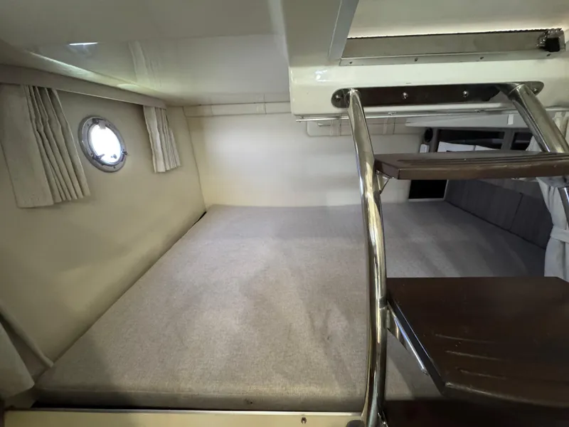 Slide: The Image of 2020 Regal 28 Express cabin interior with bed and ladder, featuring a porthole window. - 31