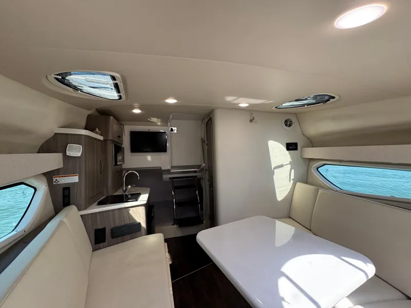 Slide: The Image of Interior of 2020 Regal 28 Express boat with modern seating, kitchenette, and windows. - 33