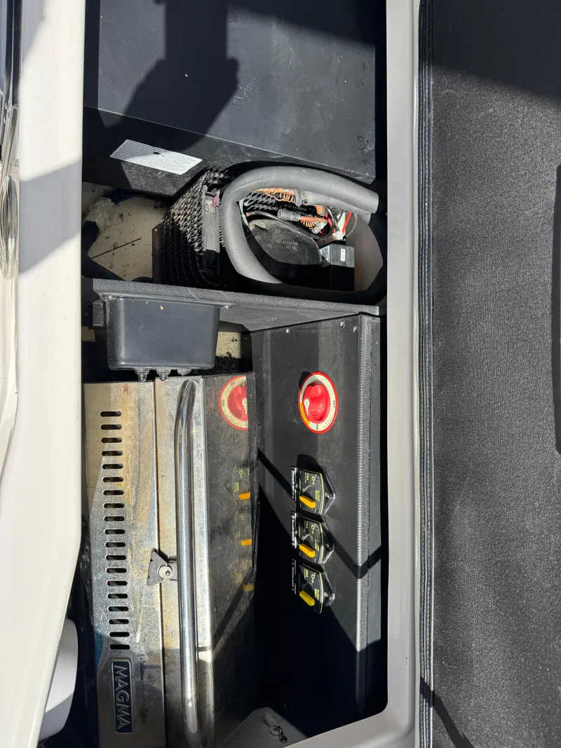 Slide: The Image of 2020 Regal 28 Express boat battery compartment with wiring and switches. - 39