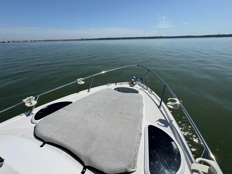 Slide: The Image of 2020 Regal 28 Express boat on calm water, featuring a spacious deck and clear sky. - 6